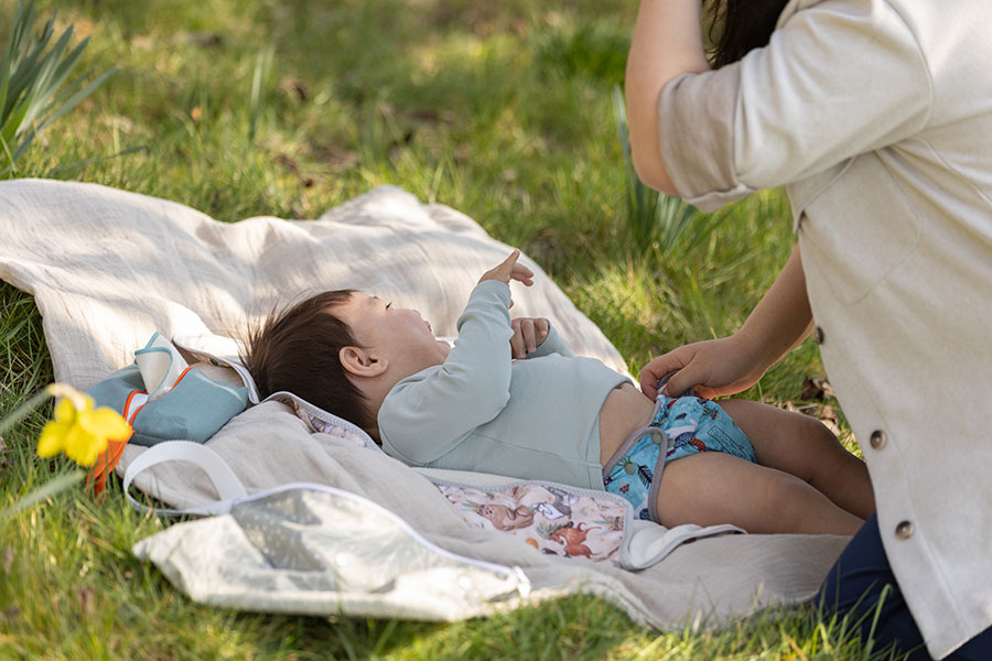 Abhaltewindel – Baby mit Mutter auf der Wiese